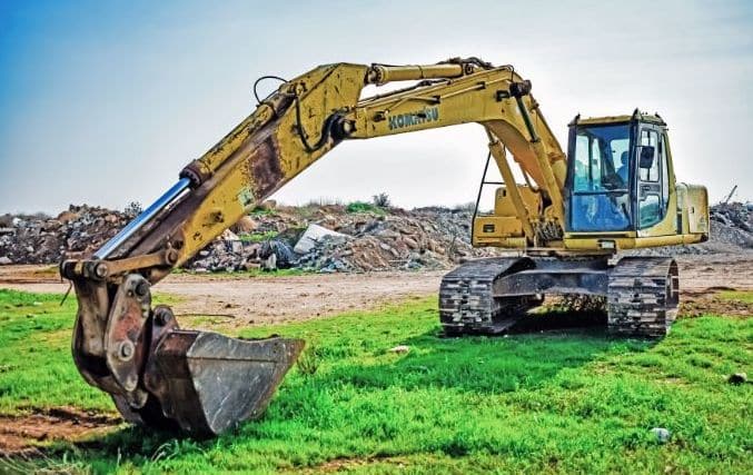 Yellow Komatsu digging machine at a landfill.