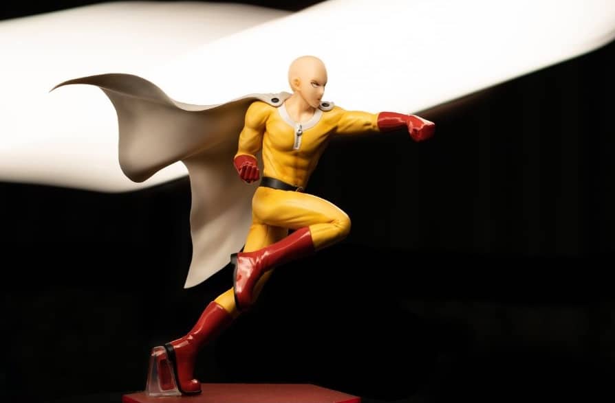 A superhero with a black cape flying and punching.