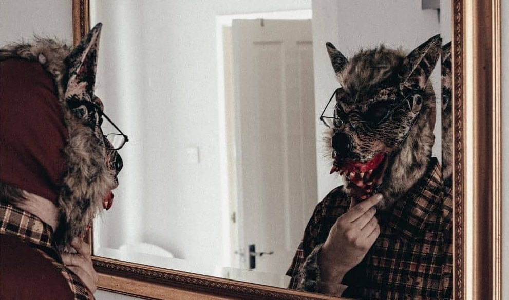 A werewolf looking at himself in the mirror.